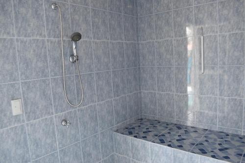 um chuveiro com uma porta de vidro na casa de banho em La Casita de chocolate em Quito