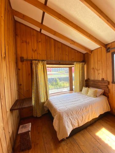 a bedroom with a bed in a room with a window at Hostal El Durmiente a 5 minutos del centro de Panguipulli in Panguipulli