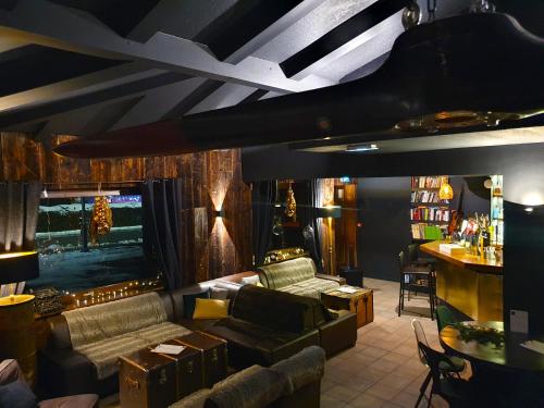 a living room with a couch and a tv at Chalet Hôtel du Bois in Les Houches