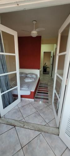 Zimmer mit einem Bett und zwei offenen Türen in der Unterkunft Suítes Praia Do Foguete in Cabo Frio