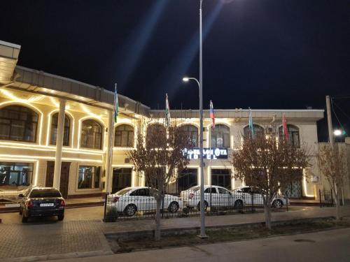 un edificio con coches aparcados delante de él por la noche en HOTEL OTA ABDUSALOM, en Samarkand