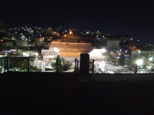 a view of a city at night at Roman Theater Hotel in Amman