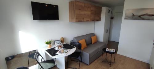 un salon avec un canapé et une table dans l'établissement Au P'tit Littoral, à Merville-Franceville-Plage