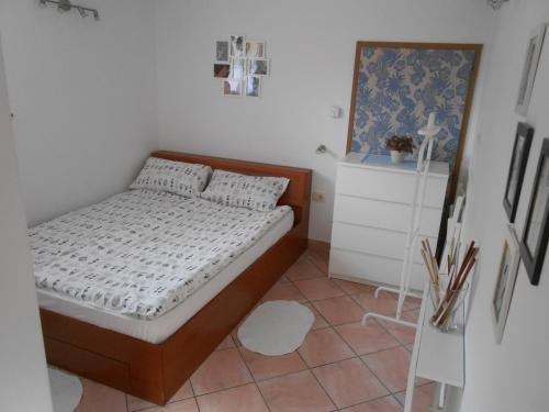 a small bedroom with a bed and a tiled floor at Love 2 Solkan in Nova Gorica