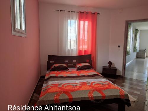 a bedroom with a bed with a red curtain at Résidence Ahitantsoa Appartement à l'étage in Mahajanga