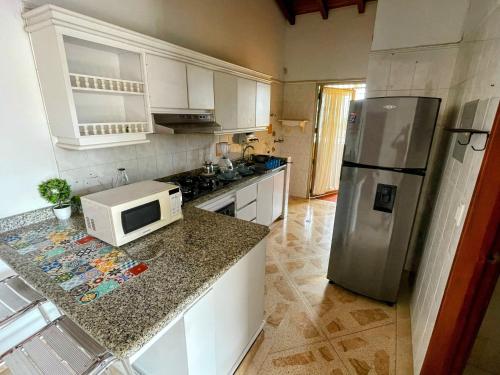 a kitchen with a refrigerator and a microwave at Apartamento en Venecia con parqueadero cubierto in Sincelejo