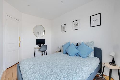 1 dormitorio con 1 cama con almohadas azules en Appartement Refait À neuf 4 Couchages, en Levallois-Perret