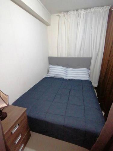 ein kleines Schlafzimmer mit einem blauen Bett und einem Fenster in der Unterkunft Mini departamento lujo in Lima