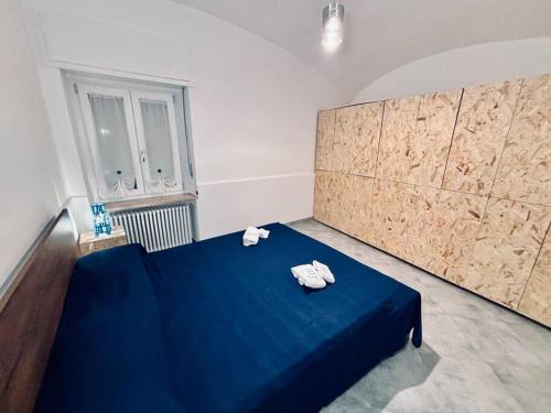 um quarto com uma cama azul com toalhas em Hd Guesthouse em Chivasso