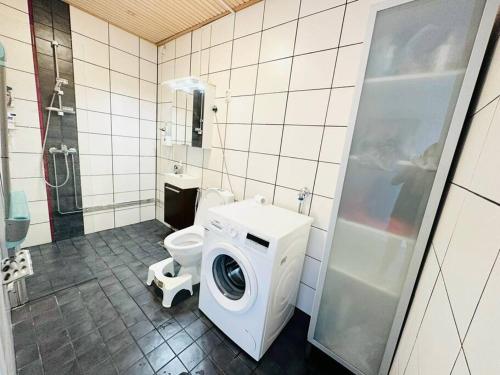 a bathroom with a washing machine and a toilet at Relax Convenient Transit Stays -shared apartment in Vantaa