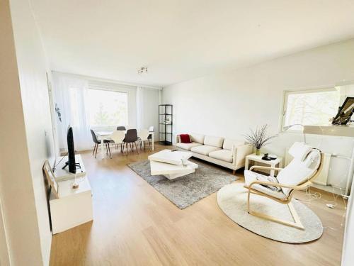 a white living room with a couch and a table at Relax Convenient Transit Stays -shared apartment in Vantaa