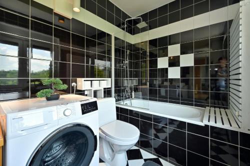 a black and white bathroom with a washing machine at Holiday House Sunny Hill in Veliko Trgovišće