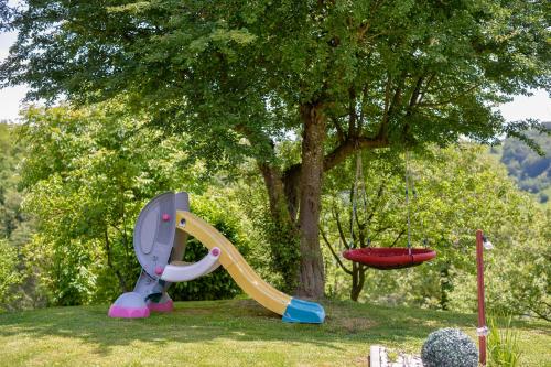 a playground with a slide next to a tree at Holiday House Sunny Hill in Veliko Trgovišće