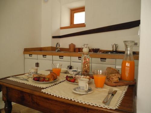 un tavolo con cibo e succo d'arancia in cucina di Casa Zefìra a Pren