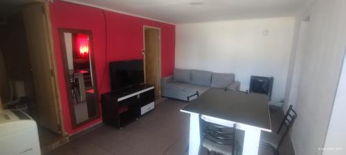 sala de estar con sofá y TV en Departamento Esquel en Esquel