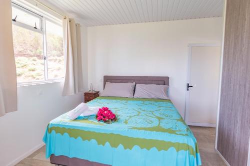 a bedroom with a bed with flowers on it at Ataku'a Lodge in Hakamui