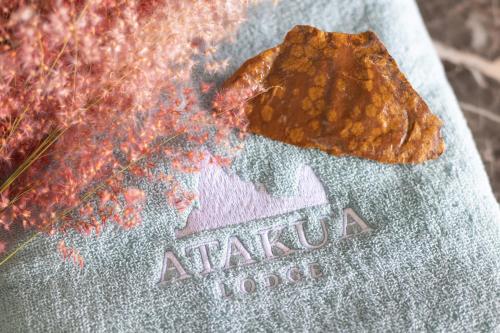 a sign that says atala hotel with a fire at Ataku'a Lodge in Hakamui