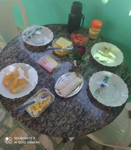 einen Tisch mit Teller mit Lebensmitteln darüber in der Unterkunft Chalé Estrela do mar 2 in Galinhos