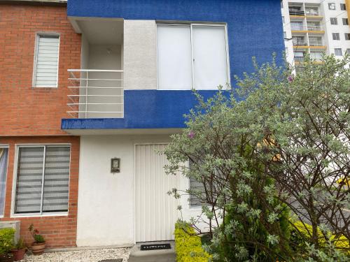 a blue and white house with a white garage at Casa vacacional en Pereira in Pereira