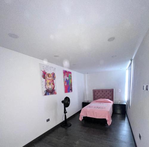 a bedroom with a pink bed and a lamp in it at Casa vacacional en Pereira in Pereira