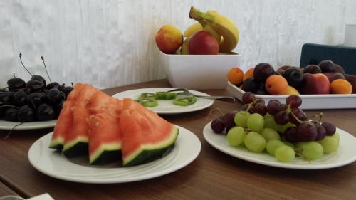 a wooden table with plates of fruit on it at Hotel Henry in Dreieich