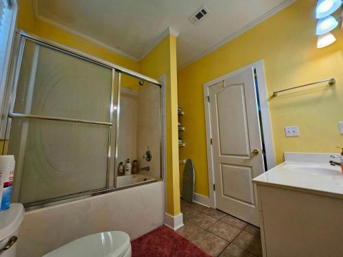 y baño con ducha, aseo y lavamanos. en Perdido Key Purple Parrot Resort, en Perdido Key