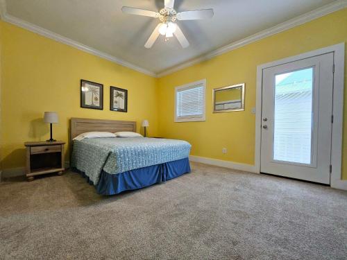 1 dormitorio con 1 cama y ventilador de techo en Perdido Key Purple Parrot Resort, en Perdido Key