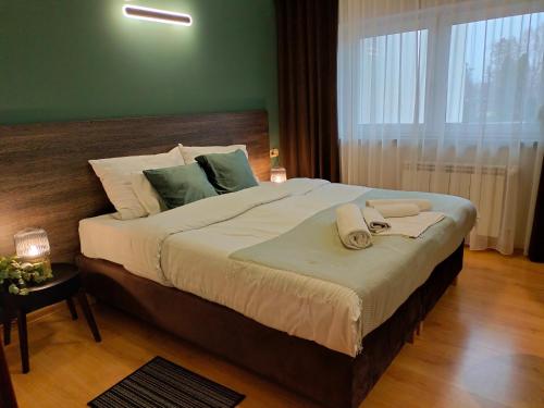 オストルフ・ビエルコポルスキにあるBankietowa Hotel & Restauracjaのベッドルーム1室(大型ベッド1台、タオル付)