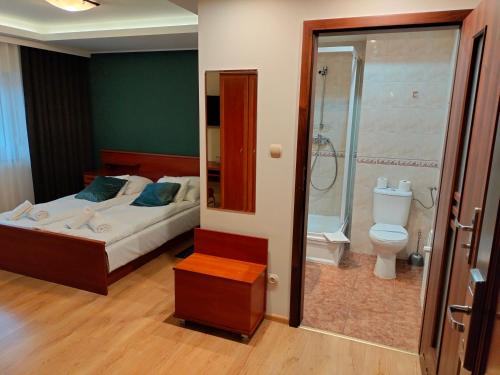 オストルフ・ビエルコポルスキにあるBankietowa Hotel & Restauracjaのベッドルーム1室(ベッド1台、シャワー、トイレ付)