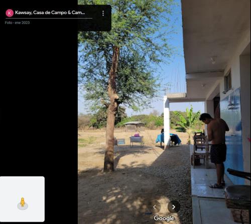 Jayanca的住宿－Kawsay, Casa de Campo & Camping，站在建筑物旁边的树旁的人