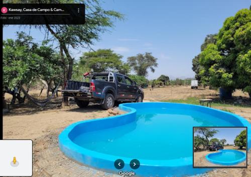 a truck parked next to a blue pool of water at Kawsay, Casa de Campo & Camping in Jayanca