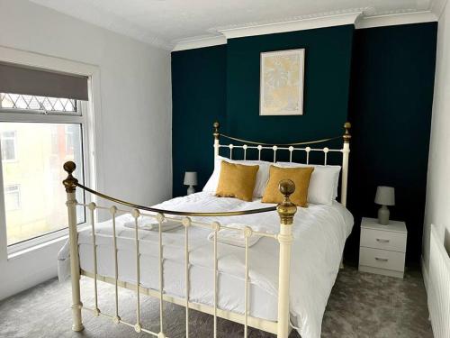 a bedroom with a bed and a blue wall at Modern Mountain Retreat in the Brecon Beacons in Ystradgynlais