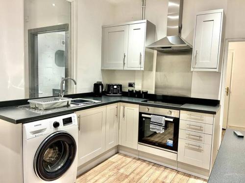 a kitchen with a washing machine and a washer at Modern Mountain Retreat in the Brecon Beacons in Ystradgynlais
