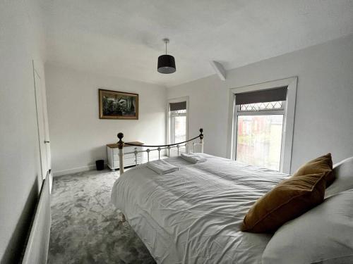 a bedroom with a large bed and a window at Modern Mountain Retreat in the Brecon Beacons in Ystradgynlais