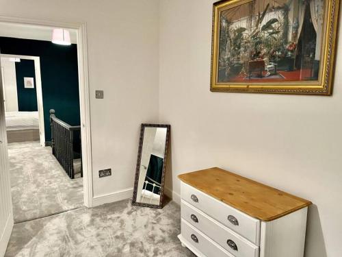 a bedroom with a dresser and a mirror on a wall at Modern Mountain Retreat in the Brecon Beacons in Ystradgynlais