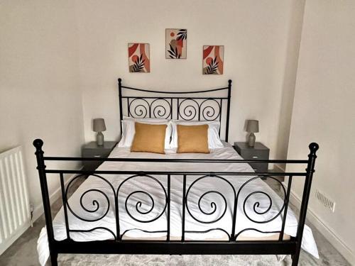 a black bed in a white room with two lamps at Modern Mountain Retreat in the Brecon Beacons in Ystradgynlais