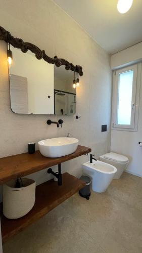 a bathroom with a sink and a toilet at Cuore di Ognina - Appartamenti vista mare in Ognina
