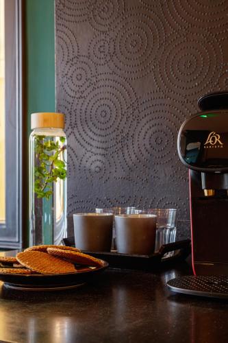 a table with a plate of food and a bottle of coffee at Boutique Hotel View in Amsterdam