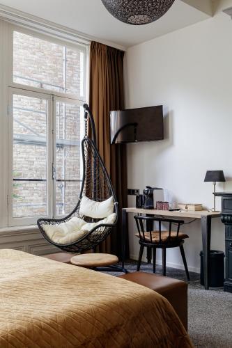a room with a bed and a chair and a desk at Boutique Hotel View in Amsterdam
