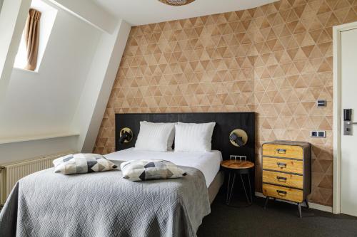 a bedroom with a bed with two pillows on it at Boutique Hotel View in Amsterdam