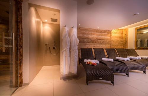 a bathroom with a row of chairs and a shower at Circle Chalets Arlberg in Zug