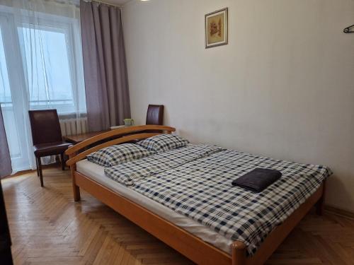a bedroom with a bed and a desk and a window at Niebieski Meander Pokoje blisko metra in Warsaw