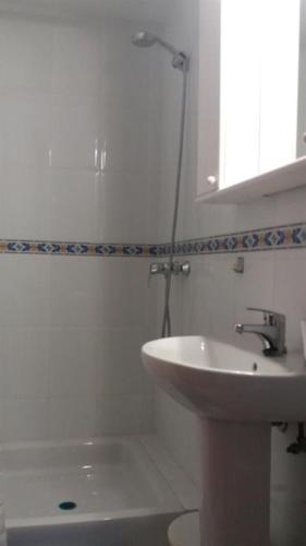 a white bathroom with a sink and a toilet at La Perla in Almuñécar