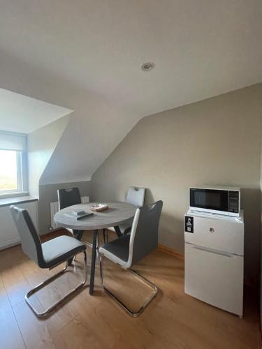 a dining room with a table and chairs and a microwave at Breezy Point Guesthouse in Donegal