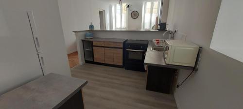 une petite cuisine avec un évier et un micro-ondes dans l'établissement Eveiller vos papilles, à Tournon-sur-Rhône