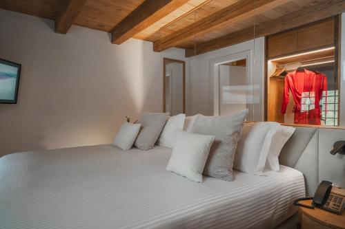 a bedroom with a white bed with white pillows at Monastero Sant'Alberico Relais in Balze