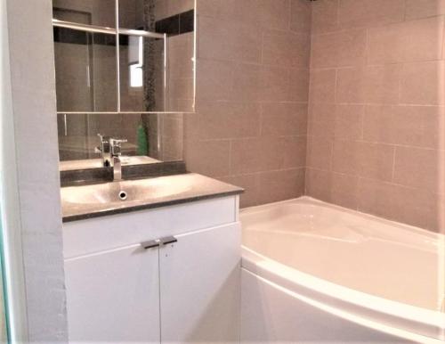 une salle de bain avec un lavabo et une baignoire dans l'établissement VILLA THETIS 4 pièces, à Antibes