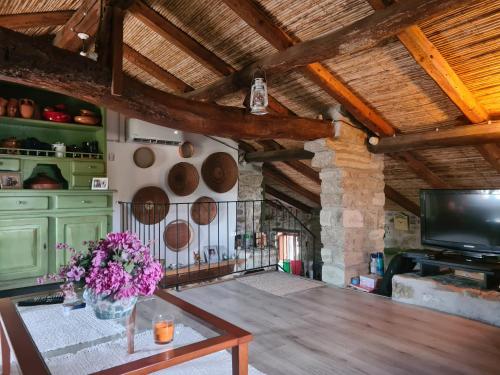 Una habitación con una mesa con un jarrón de flores. en Casa di Pietra, en Usellus