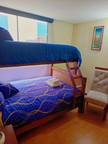 a bedroom with a bunk bed and a chair at Apartamento El Eden cerca Embajada Americana y Solca in Quito