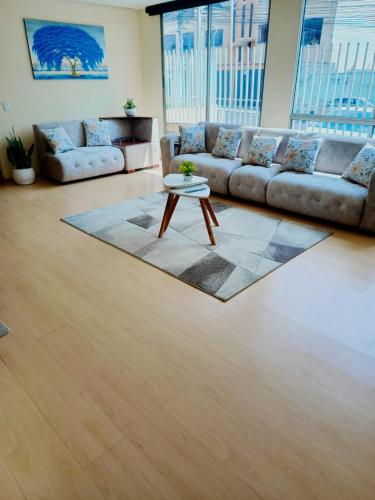a living room with a couch and a coffee table at Apartamento El Eden cerca Embajada Americana y Solca in Quito